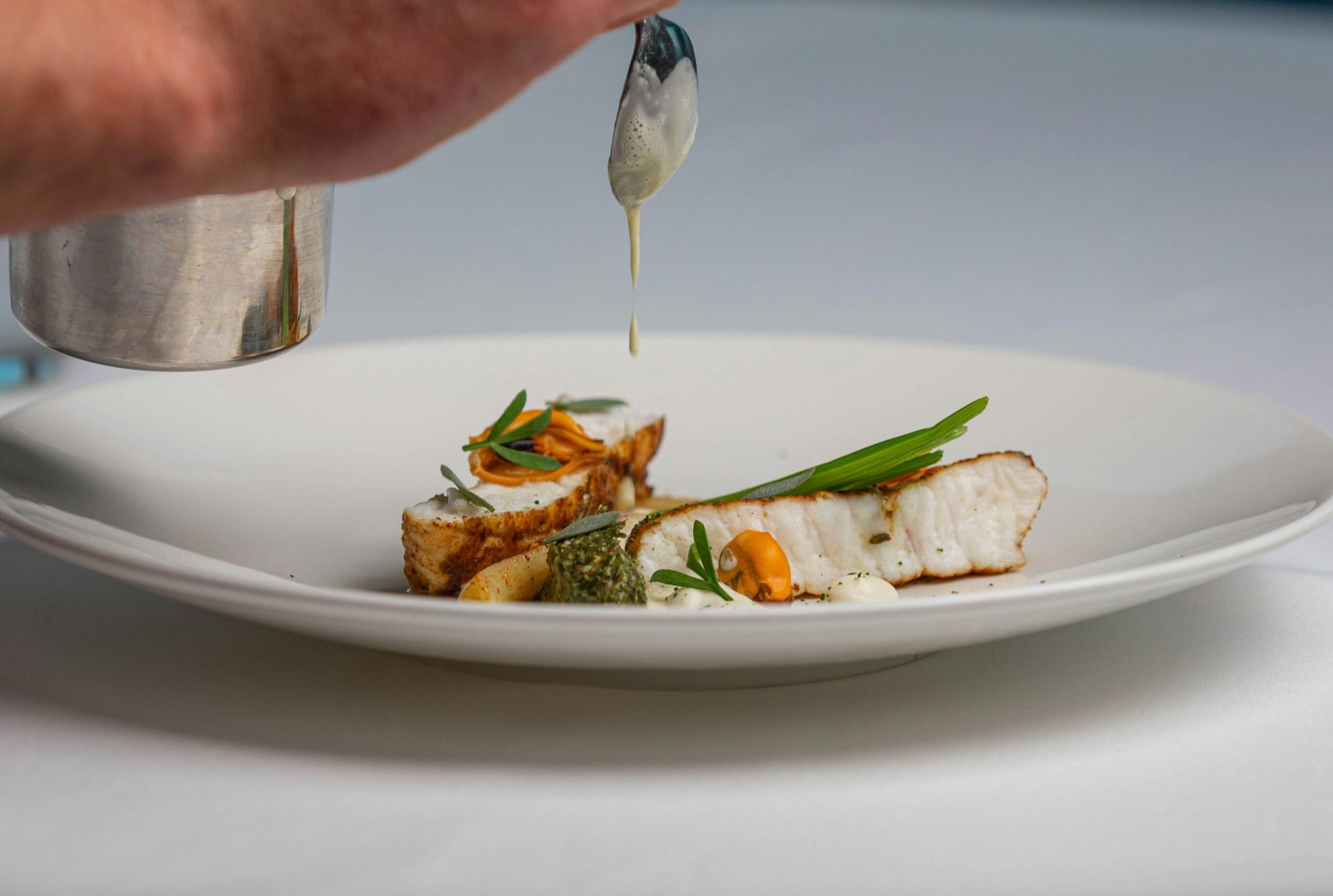 Chef finishing a plated dish during luxury catering service